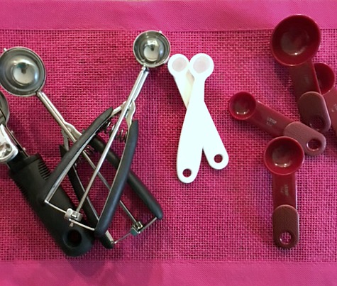 Spray measuring spoons and cookie scoops with cooking spray