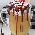 clear glass mug filled with whipped iced chocolate raspberry coffee