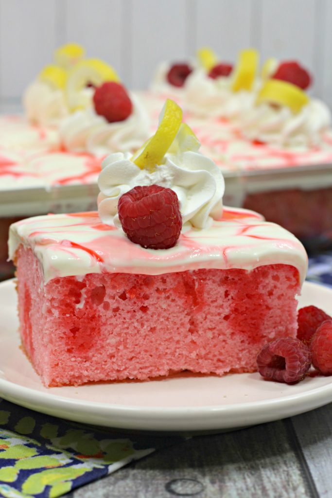slice of raspberry poke cake on a white plate 