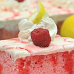 slice of raspberry poke cake on a white plate with the name in text