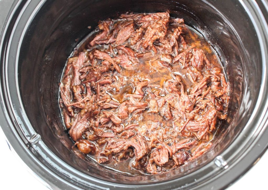 cooked and shredded beef in a slow cooker