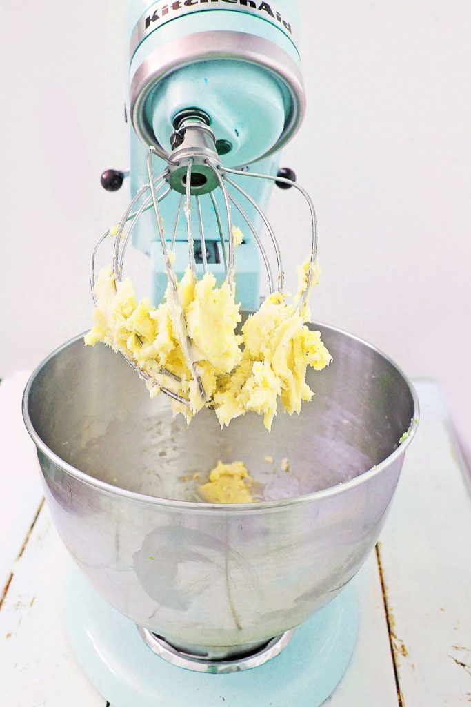 butter and sugar being creamed in a stand mixer