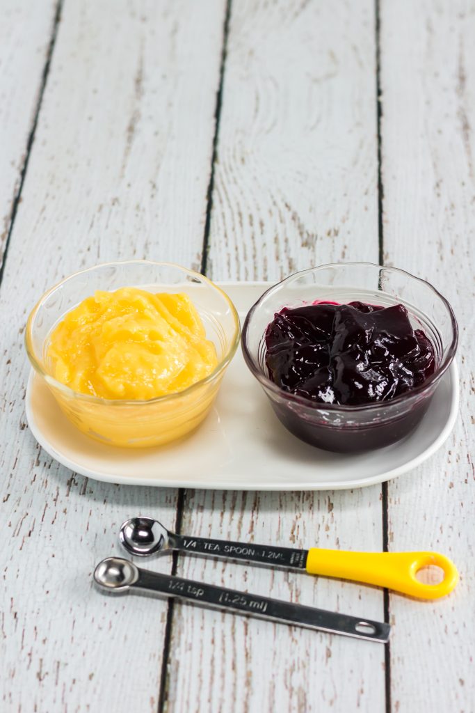 a bowl of lemon curd and a bowl of raspberry jam