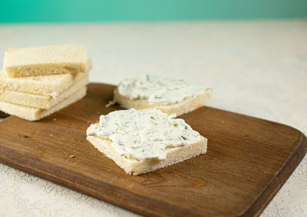 Cream cheese being spread on bread.
