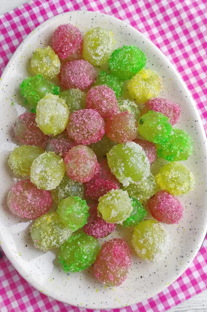 A plateful of yellow, red, and green candied grapes. 