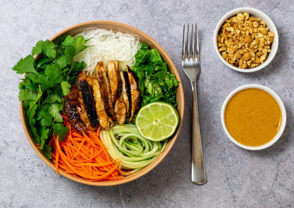Bowl full of peanut chicken with pasta.