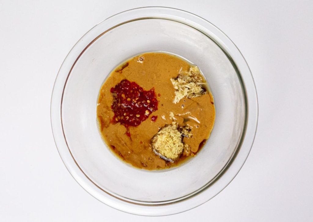 Sauce being mixed in a glass bowl.