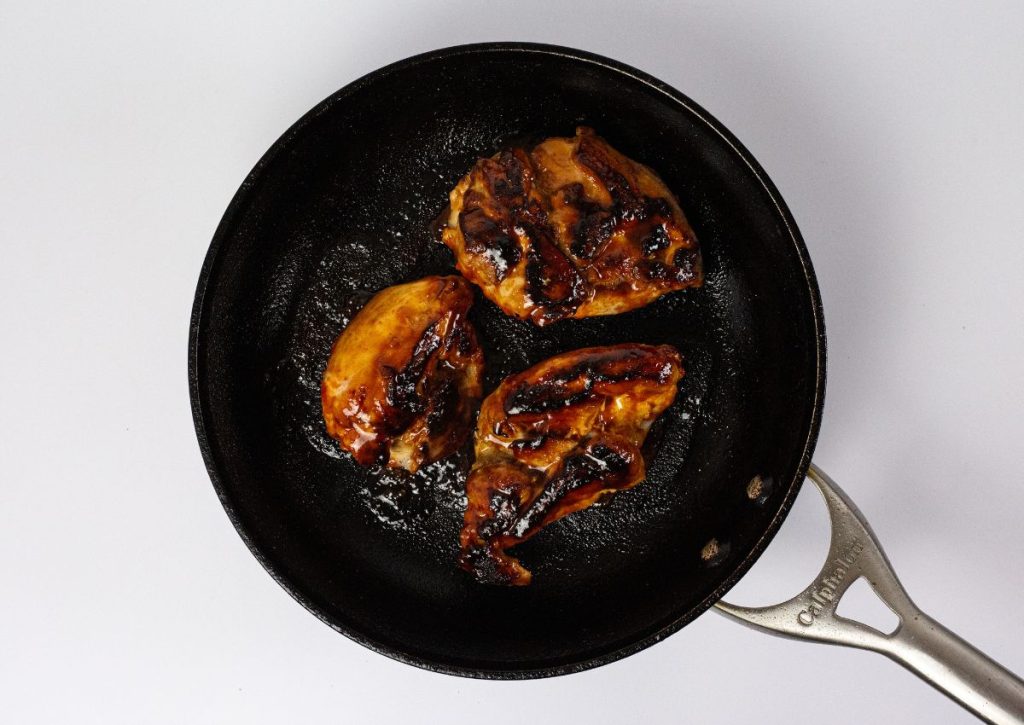 Chicken being cooked in a skillet.