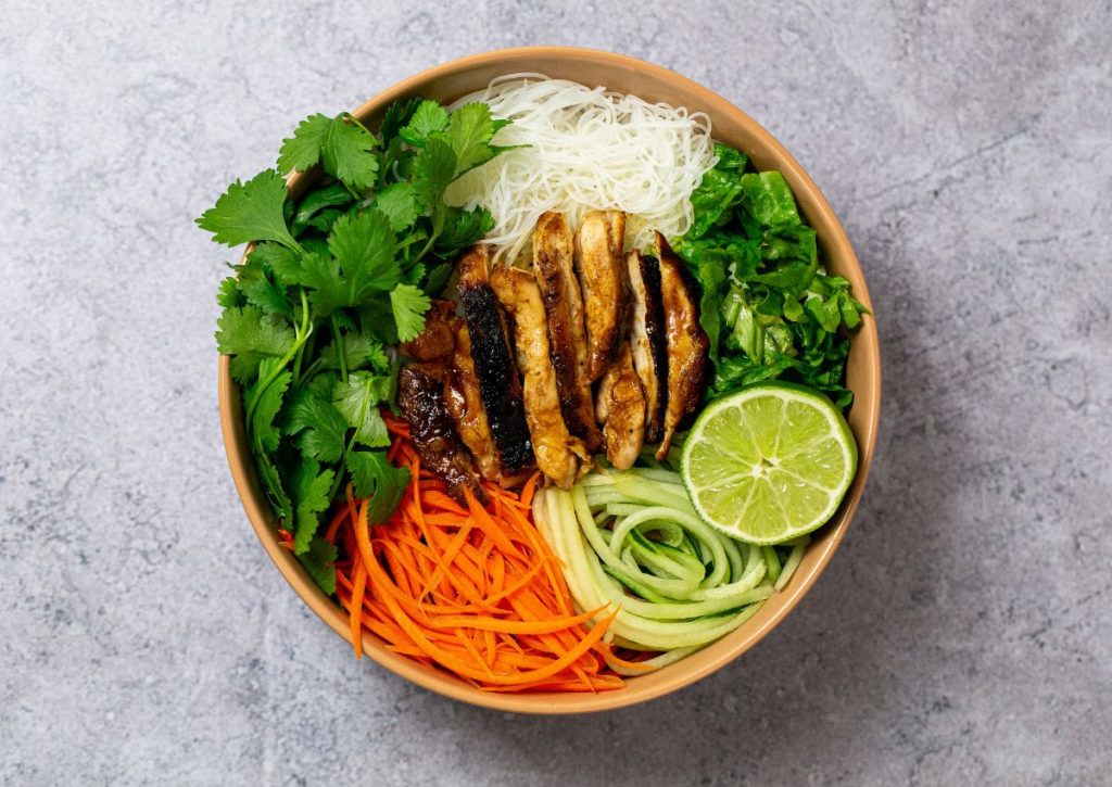 Wooden bowl full of peanut chicken.