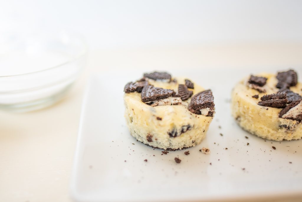 Close up of a mini Oreo Cheesecake on a white plate.