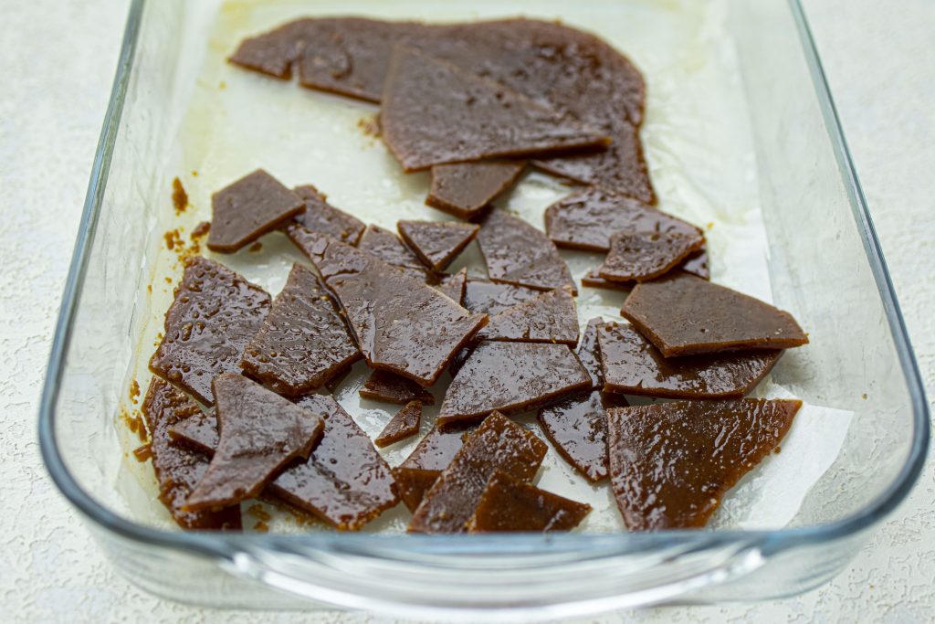 Breaking the toffee into pieces.