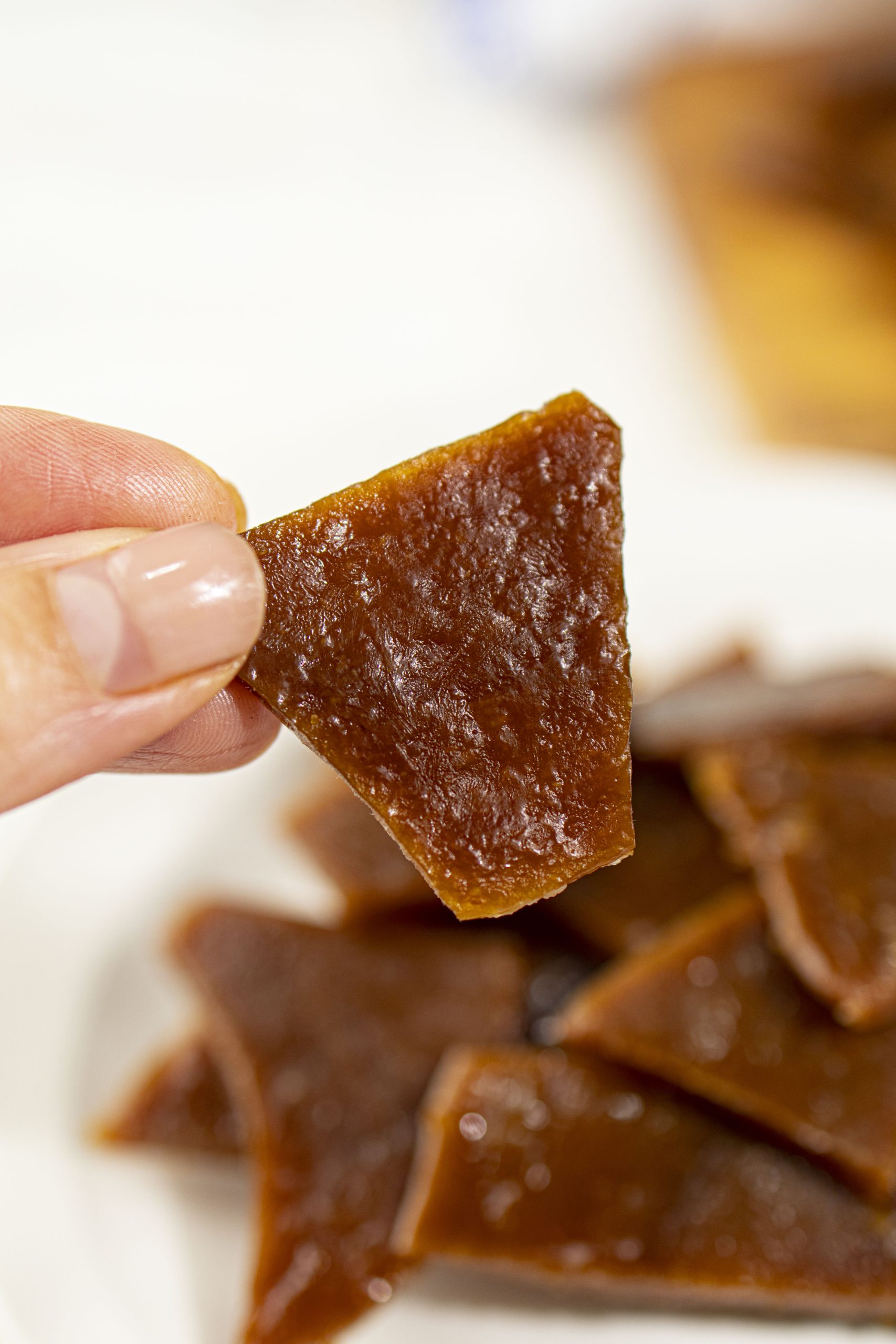 Hand holding a piece of homemade toffee.
