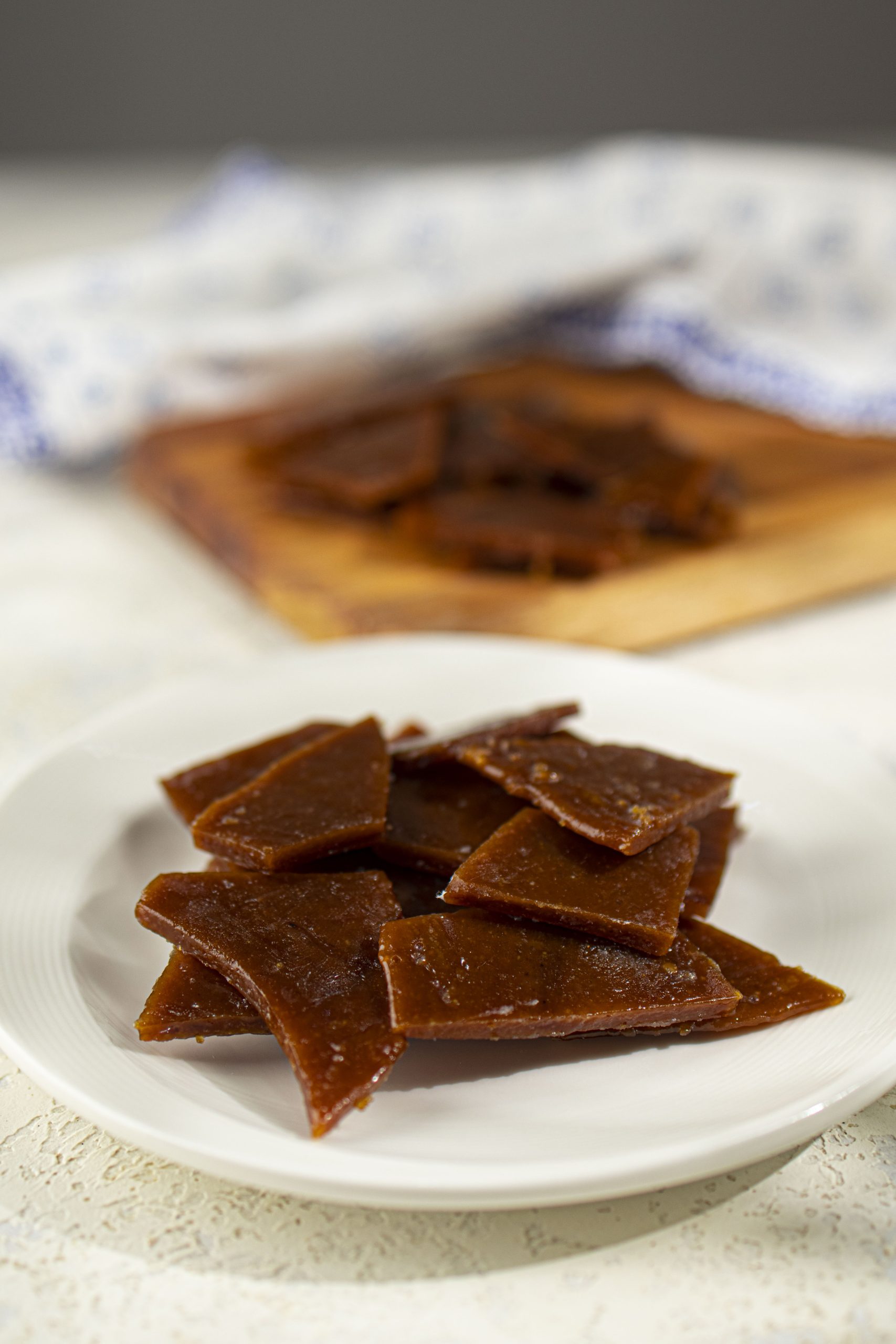 Stacked homemade toffee on a white plate.